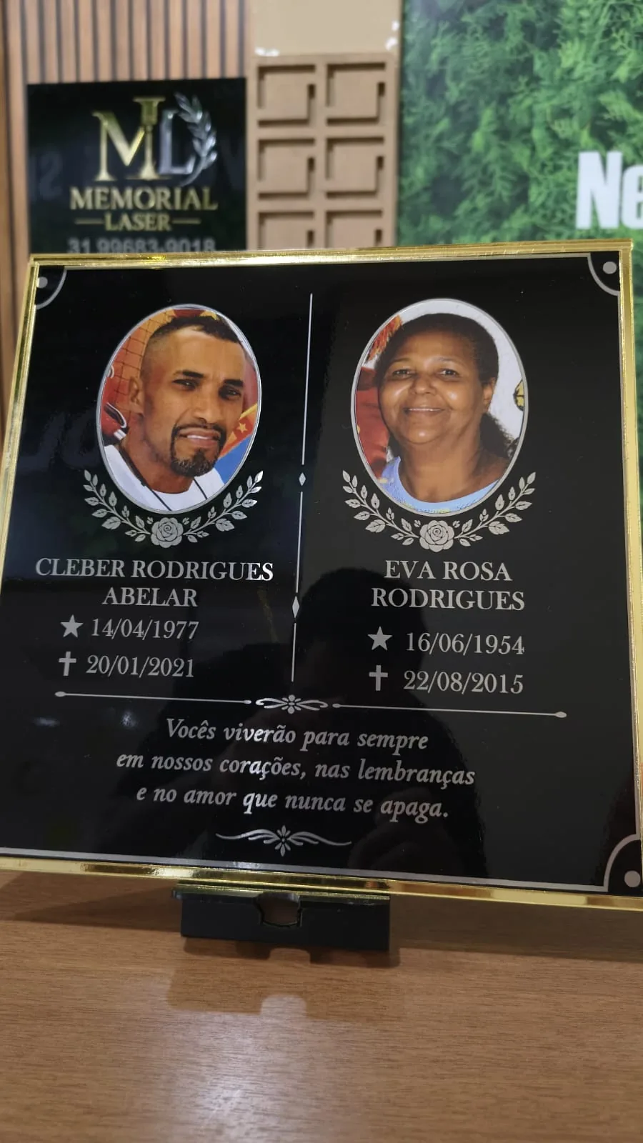 Placa memorial para duas pessoas com fotos e datas